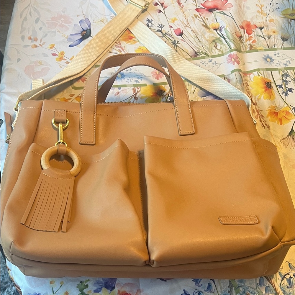 Skip & Hop baby bag. Tan with Front Pockets and side pockets and Tassel